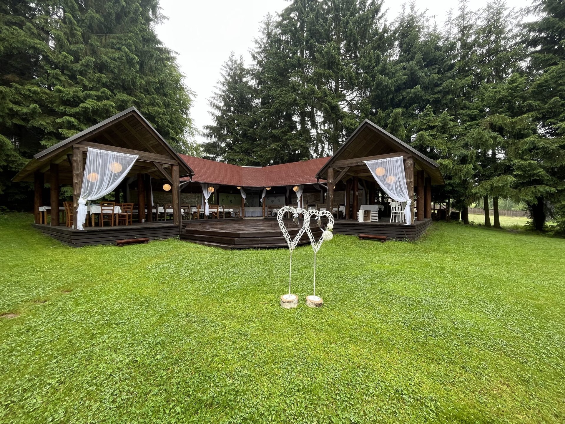 Dřevěný pavilon zasazený do lesní zahrady